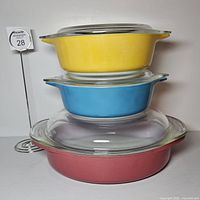 Stacked view showing all three coloured casseroles and two lids