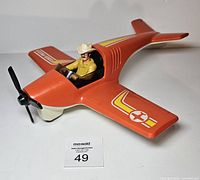 Top view of orange Fisher-Price airplane with pilot seated in cockpit