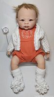Front view of doll seated with full outfit visible