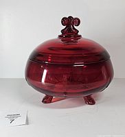 Front view of ruby red Viking Glass candy dish with lid on three feet
