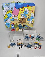 Group shot with tin and several figurines displayed on clear risers