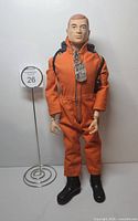 GI Joe figure dressed in orange jumpsuit with backpack, boots, dog tag visible