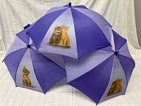 Three children’s umbrellas grouped to show kitten graphics and alternating purple panels