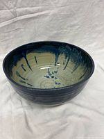 Angled view showing exterior cobalt glaze and interior drip pattern