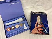 Open storage case showing nail tool, five attachments, and outer box