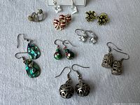 All eight pairs of earrings displayed on fabric