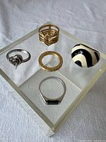 Group of five assorted rings on display block