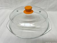 Top view of glass microwave cover showing dome, vents, orange knob