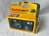 Front of boxed Kodak MAX HQ camera showing product name, 27 exposures, window revealing camera