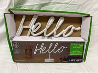 Sign in opened box showing full "Hello" tubing and base