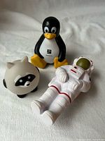 Front view of penguin, raccoon and astronaut squeeze figures