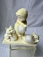 Front view of Snowbabies "Fur Balls" figurine showing child figure, two cats, fur balls on snowy base