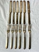 Full set of six knives and six forks displayed on cloth