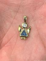 Front view of gold-plated angel pendant showing blue topaz and CZ