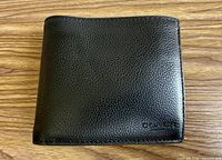 Front view of closed black Coach wallet