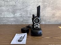 Front view of two radios in charging base with adapter and manual visible