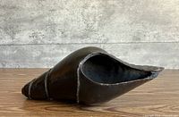 Full view of bronze conch shell sculpture, right side