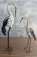 Full view of both heron figurines standing on table