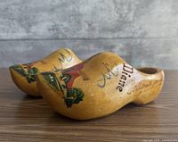 Top and side view of both clogs showing painted scenes and overall appearance