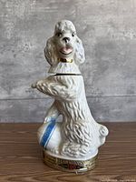 Front view of white poodle decanter with removable head and base label