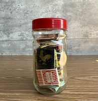 Front view of glass jar showing red lid and packed matchbooks