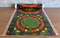 Roll of multicolour stained-glass style window film partially unrolled on table