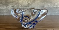 Angled side view showing clear crystal with cobalt blue swirl ribbons