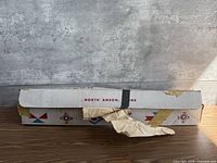 Full view of cardboard box front, taped and torn