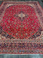 Full view of red Persian Kashan rug showing overall pattern and borders