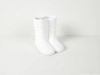 front three-quarter view of glossy white ceramic boots planter