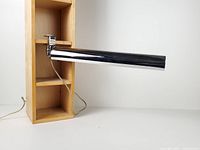 Full view of chrome tubular swing arm lamp clamped to shelf