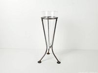 full view of vase seated in tripod stand