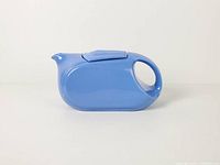 Side profile of blue Hall China refrigerator pitcher with lid attached