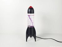 Lamp unplugged showing full rocket shape, cord, matte black base and red tip