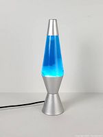 Full view of silver Lava Lite lamp plugged in and operating