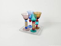 Four multicolor beaded stem shot glasses arranged on frosted tray