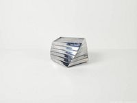 Front view of six stacked square metal coasters forming twisted column
