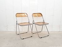 Two amber acrylic folding chairs front view