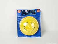 Front view of packaged smiley face touch light