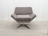 Front view showing angular design, upholstery, and base