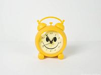 Front view of yellow smiley face alarm clock