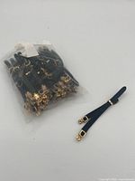 sealed bag containing numerous black straps plus one strap displayed to show both sides