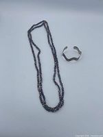 Entire lot: pearl necklace laid extended and sterling cuff bracelet