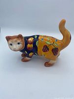 Left side view of glazed ceramic cat with fruit pattern