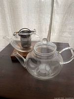 Both glass teapots and bamboo trivet overview