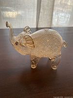 Left side view of clear textured glass elephant with gold accents