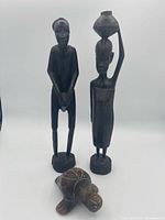 Overall view of two wooden figurines and turtle whistle