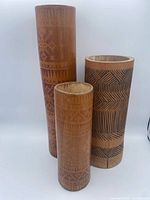 Three bamboo containers standing side by side showing height differences and patterns