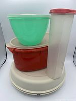 Stacked view of all four Tupperware pieces showing colours, shapes and lids