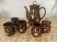 Full set showing teapot, sugar bowl, creamer and three mugs
